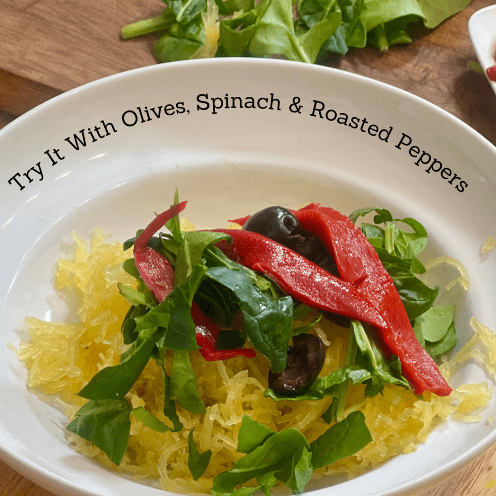 A bowl of spaghetti squash with olives spinach and roasted peppers